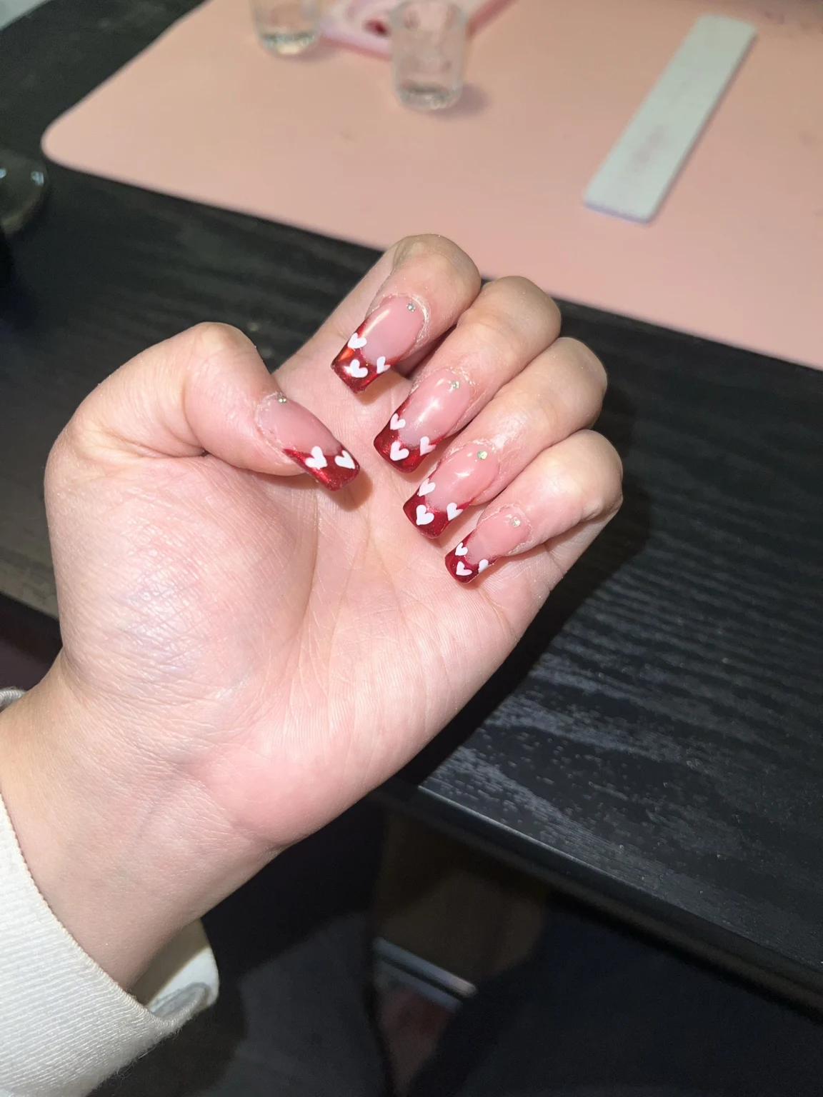 Carlita’s original nail work: red tips + white hearts
