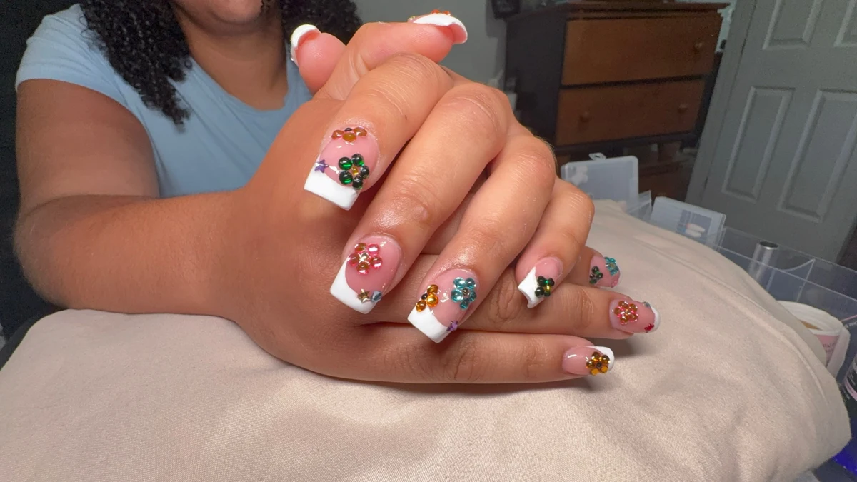 Carlita’s original nail work: white tips + jewel flowers